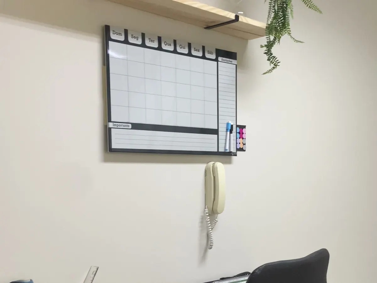 Mesa de trabalho com quadro de planejamento no escritório da MV Engenharia