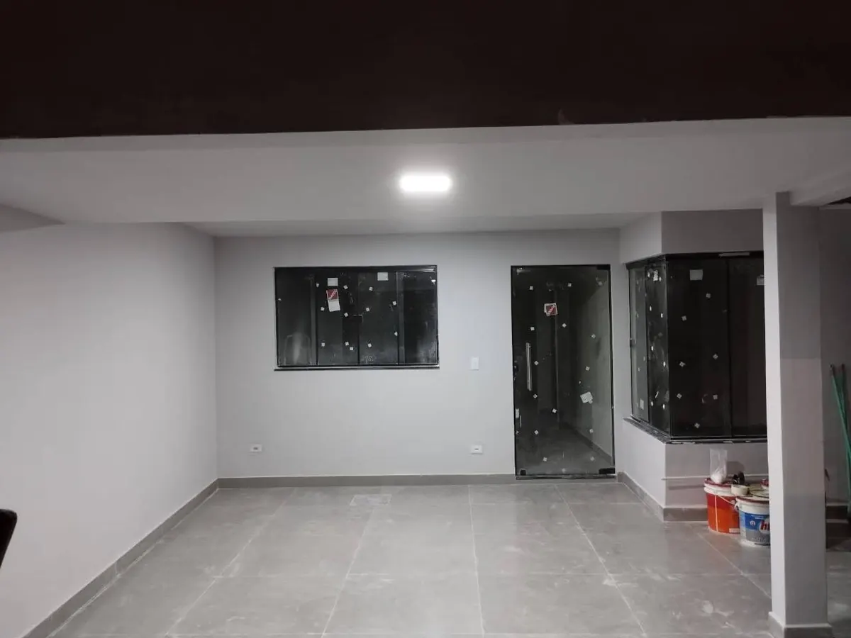 Sala integrada entregue, com piso cinza e divisória de vidro