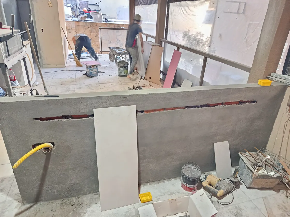 Equipe trabalhando no reboco e no piso de uma varanda