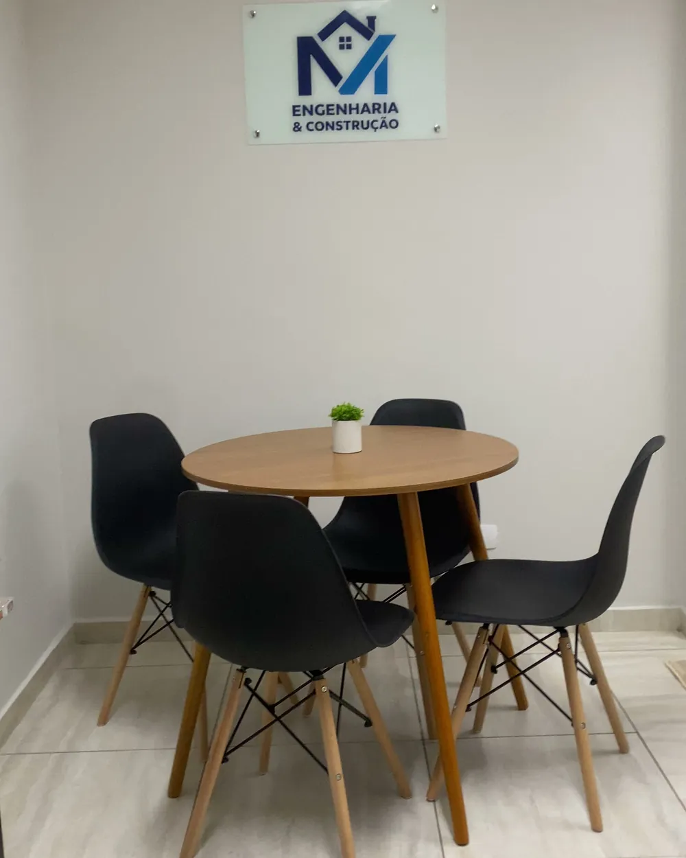 Sala de reunião do escritório da MV Engenharia, com a placa da marca na parede